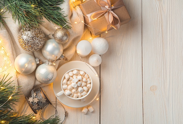 Decoração de natal, café com marshmallows e um presente à luz