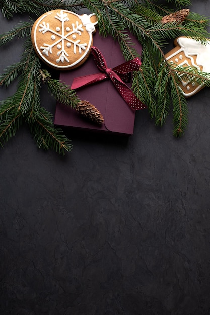 Decoração de Natal com cones de ramos de abeto e caixas de presentes em um fundo escuro vertical