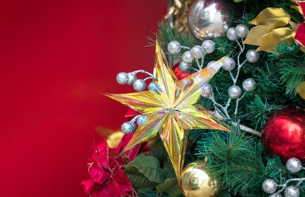 Decoração de natal com estrela na árvore com fundo vermelho