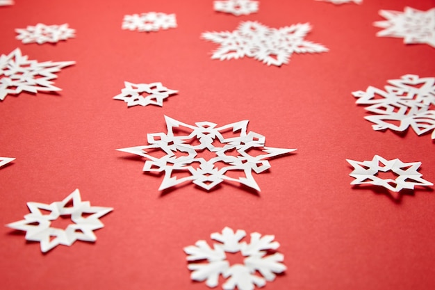 Foto decoração de natal com flocos de neve de papel branco sobre fundo vermelho