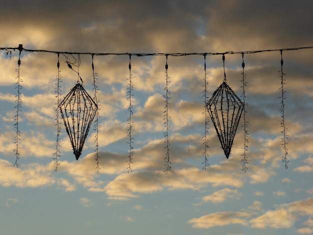 Decoração de natal com luzes no fio contra céu nublado