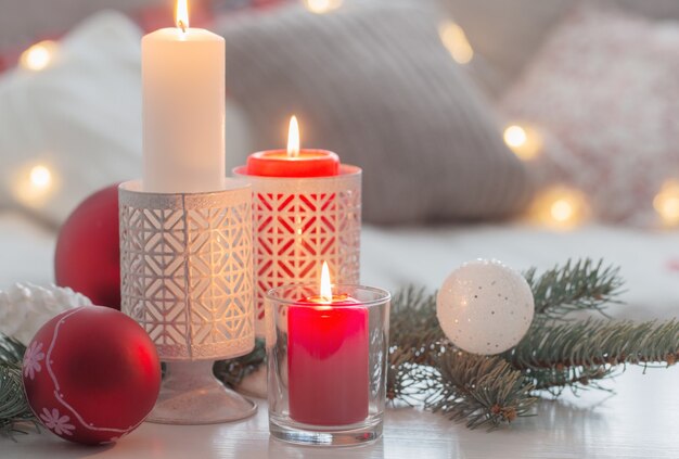 Decoração de Natal com velas e bolas na mesa branca interna