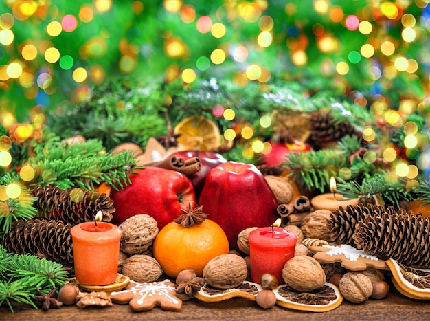 Decoração de Natal com velas. Frutas, nozes, especiarias e biscoitos. Luzes desfocadas