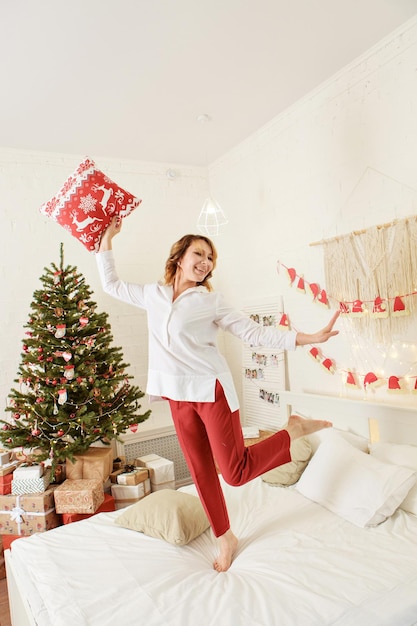 Decoração de Natal e conceito de celebração de ano novo uma grande árvore de Natal com presentes na cama