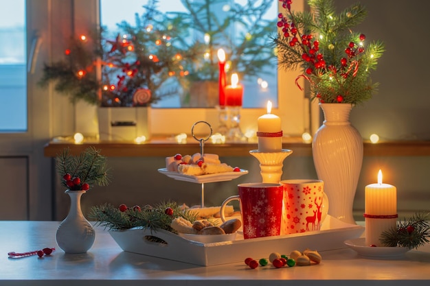 Decoração de natal e copos vermelhos com bebida quente na cozinha