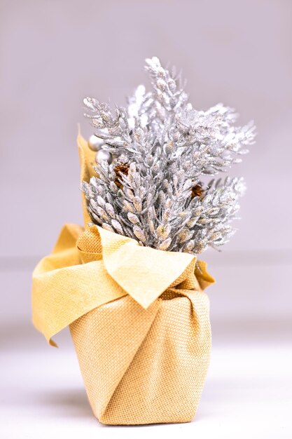 Decoração de Natal feita de ramos prateados em tecido dourado. Elementos do interior do ano novo.