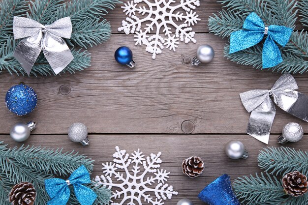 Decoração de Natal. Galho de árvore do abeto com bolas, solavancos, floco de neve e arcos em um fundo cinza