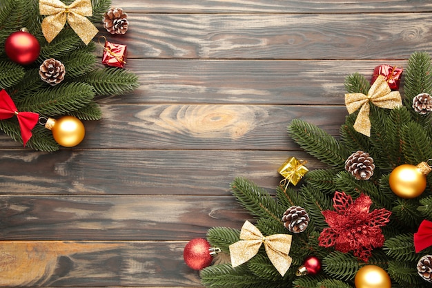 Decoração de Natal. Galho de árvore do abeto com bolas vermelhas e douradas sobre fundo marrom