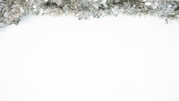 Decoração de natal isolada no fundo branco. enfeites de natal de ouropel de prata com espaço de cópia para o texto. guirlanda de fita de decoração realista de ano novo. elemento de design para cartão de comemoração ou folheto