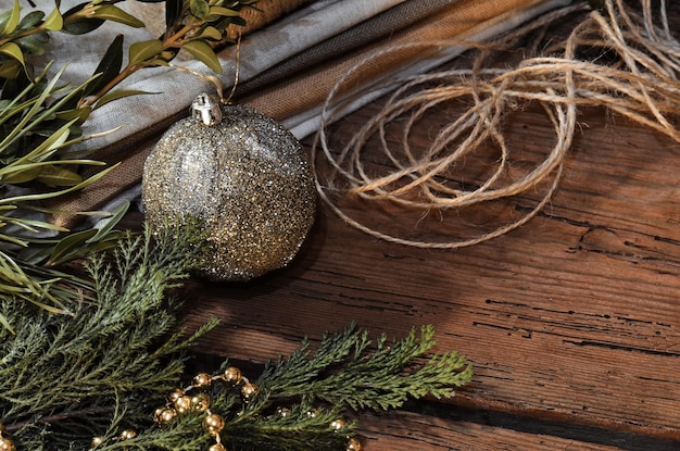 Decoração de natal na mesa vintage de madeira Decoração de natal com galhos de árvores de pele, corda de juta e pano de saco