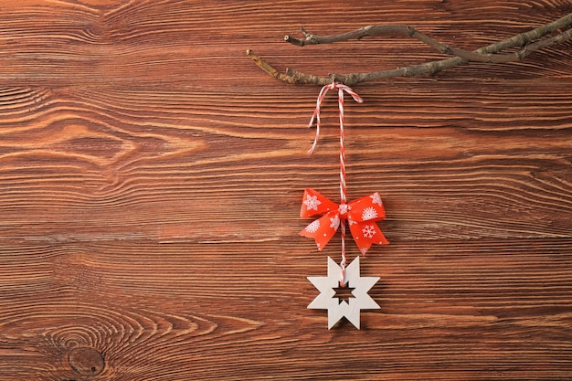 Foto decoração de natal pendurada em galho contra fundo de madeira