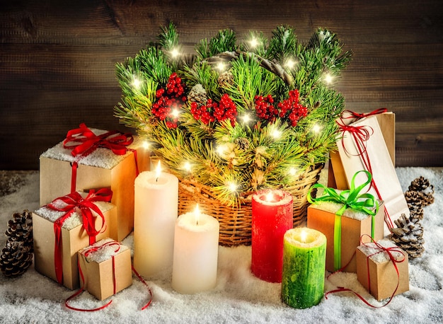 Decoração de natal queimando velas e caixas de presente. galhos de árvores de natal com luzes. imagens de estilo vintage em tons. cores vibrantes