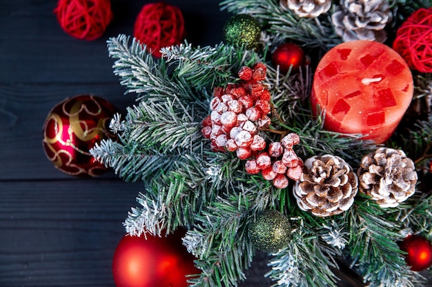 Foto decoração de natal ramos de abeto bolas vermelhas velas bolas de rattan cones bagas vermelhas em hoarfrost humor de férias decoração de casa