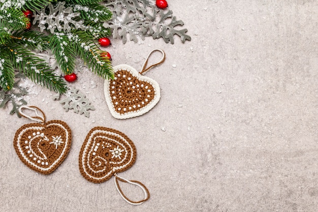 Decoração de Natal. Árvore do abeto do ano novo, folhas frescas, corações de biscoitos de gengibre de malha e neve artificial.