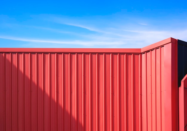 Decoração de parede de aço ondulado vermelho fora do edifício moderno em estilo industrial com céu azul