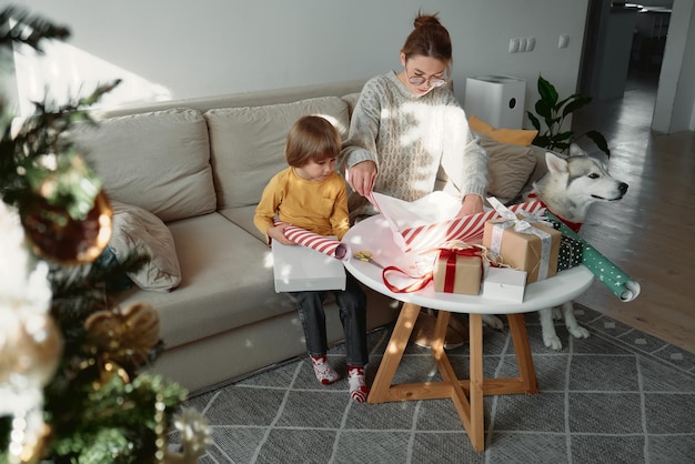 Decoração de presentes de natal família mãe filho e cachorro de estimação embrulhando caixa de presente de natal juntos