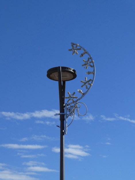 Decoração de rua de Natal na lâmpada de rua contra o céu azul