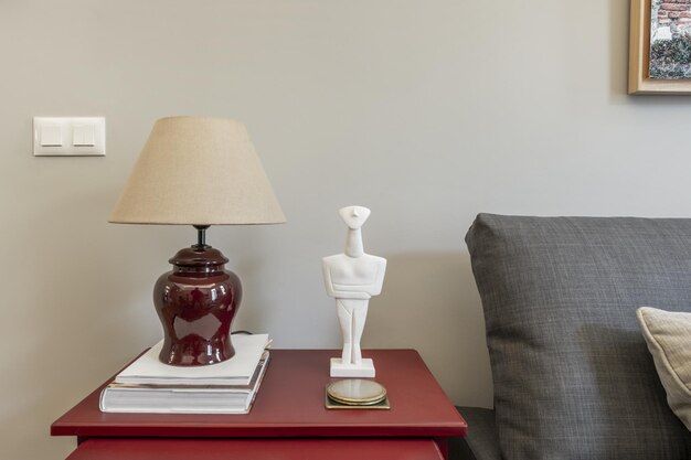 Decoração de uma sala de estar com uma mesa de madeira pintada de vermelho e acessórios decorativos