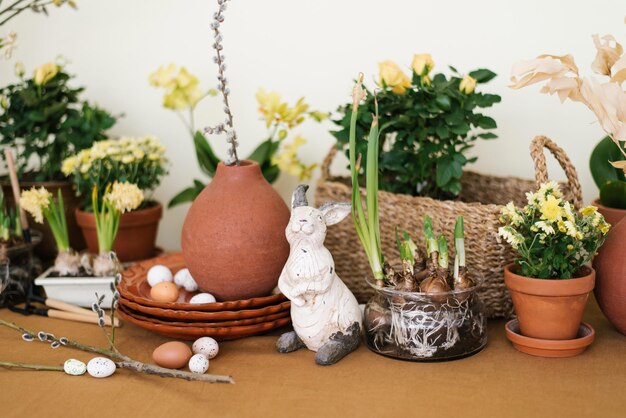 Decoração do feriado de Páscoa Narcisos e jacintos em um pote de ovos e uma estatueta de coelho e galhos