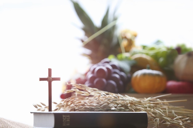 Foto decoração e fundo de frutas abundantes no dia de ação de graças da igreja com a bíblia e a cruz de jesus