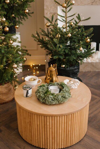 Decoração elegante de Natal Uma mesa com uma coroa de flores e canecas na sala de estar