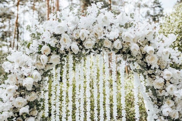 Decoração em arco com flores brancas para cerimônia de casamento na natureza