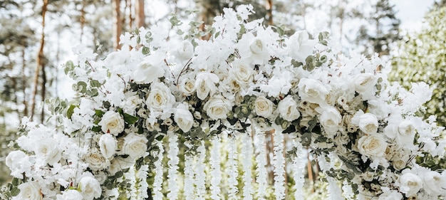 Decoração em arco com flores brancas para cerimônia de casamento na natureza