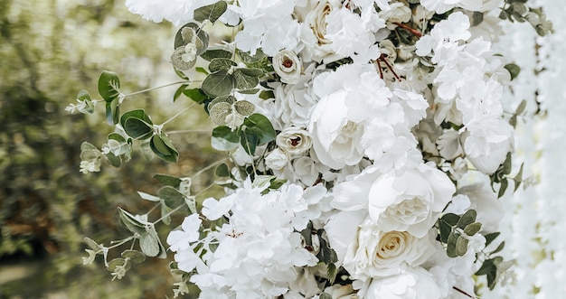 Decoração em arco com flores brancas para cerimônia de casamento na natureza