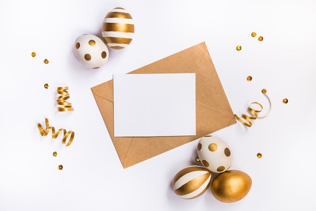 Decoração festiva de Páscoa. Vista superior de ovos de Páscoa e cartão vazio em um envelope kraft.