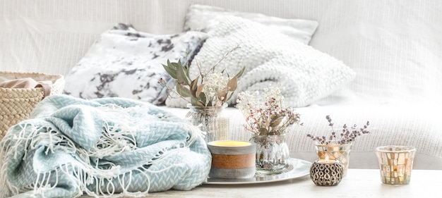 Decoração para casa no interior. cobertor turquesa e cesta de vime com um vaso de flores e velas