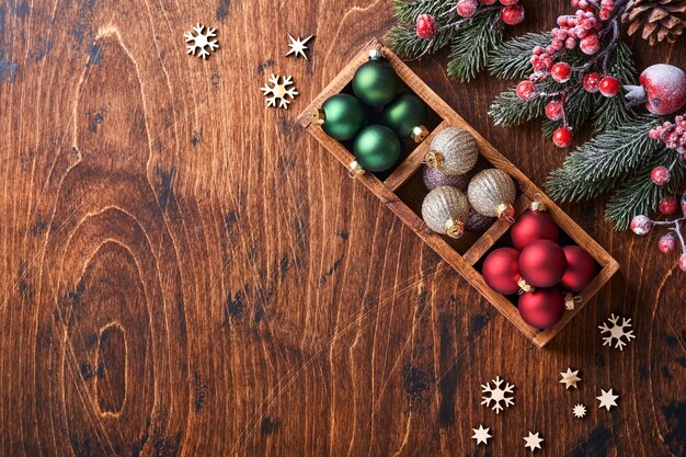 Decoración de abeto bolas de Navidad rojas y verdes, canela en forma y rodajas de naranjas secas sobre fondo de madera para tus saludos navideños. Vista superior con espacio de copia. Tarjeta de felicitación de Navidad.