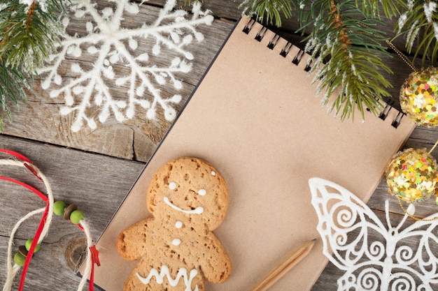 Decoración de abeto de Navidad y bloc de notas en blanco sobre fondo de tablero de madera