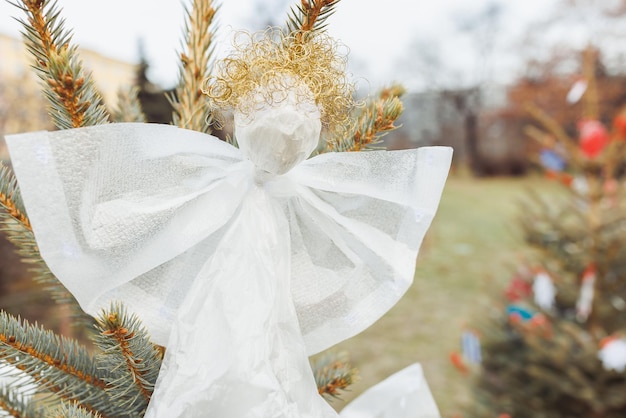 Decoración de ángel hecha a mano con lámina de plástico y alambre en el árbol de Navidad