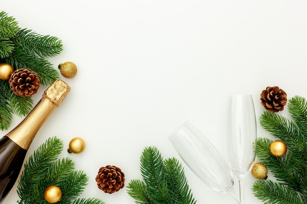 Decoración de año nuevo con botella de champagne y ramas de abeto