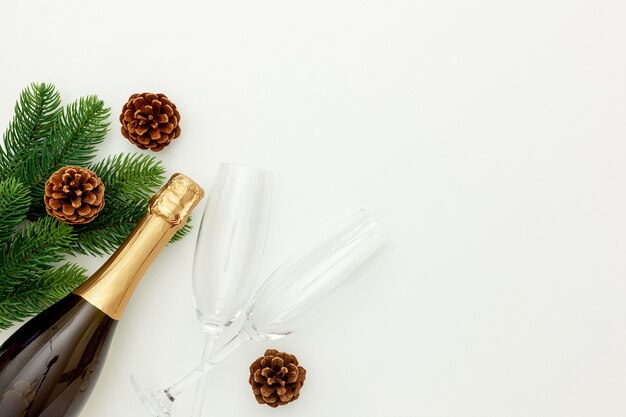 Decoración de año nuevo con botella de champagne y ramas de abeto