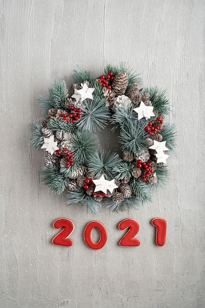 Decoración de año nuevo con corona de Navidad y número 2021. Patrón de vacaciones de invierno.