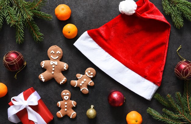 Decoración de año nuevo con gorro de Papá Noel, mandarinas y pan de jengibre