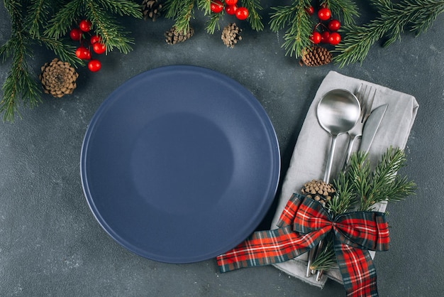 Decoración de año nuevo y servicio de Navidad. Plato azul vacío con cubiertos en la mesa. Concepto de menú de recetas de cena de comida de maqueta