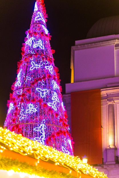 Decoración del árbol de navidad en un centro de ciudad moderno en la noche