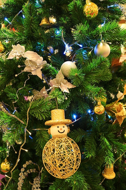 Decoración del árbol de Navidad con muñeco de nieve y adornos de bolas.