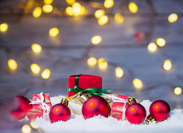 Decoración del árbol de Navidad en la nieve con luces y regalos con espacio para copiar