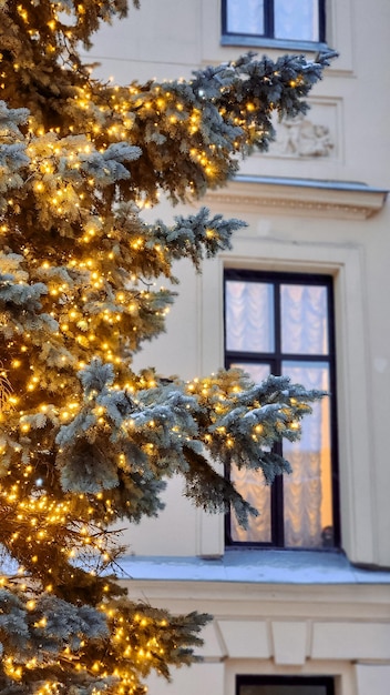 Decoración del árbol de Navidad con nieve que cae Luces bokeh coloridas Fondo dorado para las vacaciones de Año Nuevo