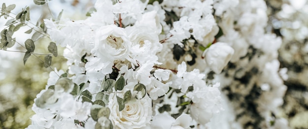 Decoración de arco con flores blancas para una ceremonia de boda en la naturaleza.