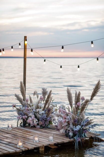 Decoración de boda de mar en la costa. Ceremonia de boda por la noche cerca del agua