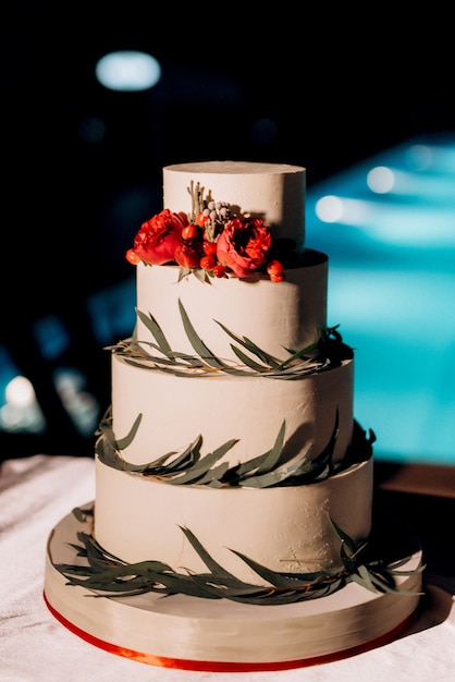 Decoración de boda con pastel en un banco de madera con un fondo de cascada