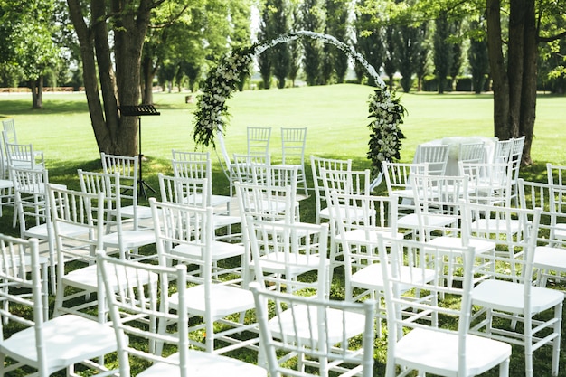 Decoración de bodas con sillas blancas y flores blancas.