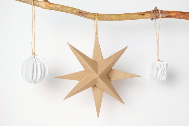 Decoración de bolas y estrellas de papel de Navidad Decoración nórdica de Navidad hecha a mano sobre un fondo claro contra la pared Diseño de estilo bohemio escandinavo Adorno mínimo de bricolaje Origami estructural Cero desperdicio