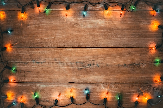 Decoración de bombilla de luces de Navidad vintage en tablón de madera vieja. Fondo de vacaciones feliz Navidad y año nuevo.