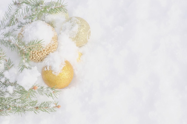 Decoración de borde de navidad y rama de árbol de navidad en la nieve Ramas de árboles de navidad con adornos dorados en la nieve blanca Vista superior plana