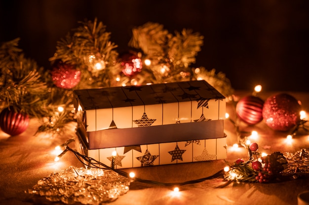 Decoración de cajas de regalo de Navidad con luces de velas y árboles de Navidad en la mesa de madera con luces bokeh